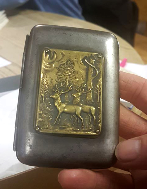 Gun metal and case approx 5 x 8cm, with brass relief plaque of stags in a forest
