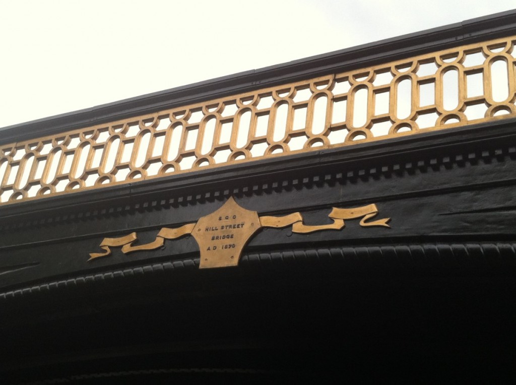 Gold painted plaque with black lettering spelling out S.G.C Hill Street Bridge A.D. 1870