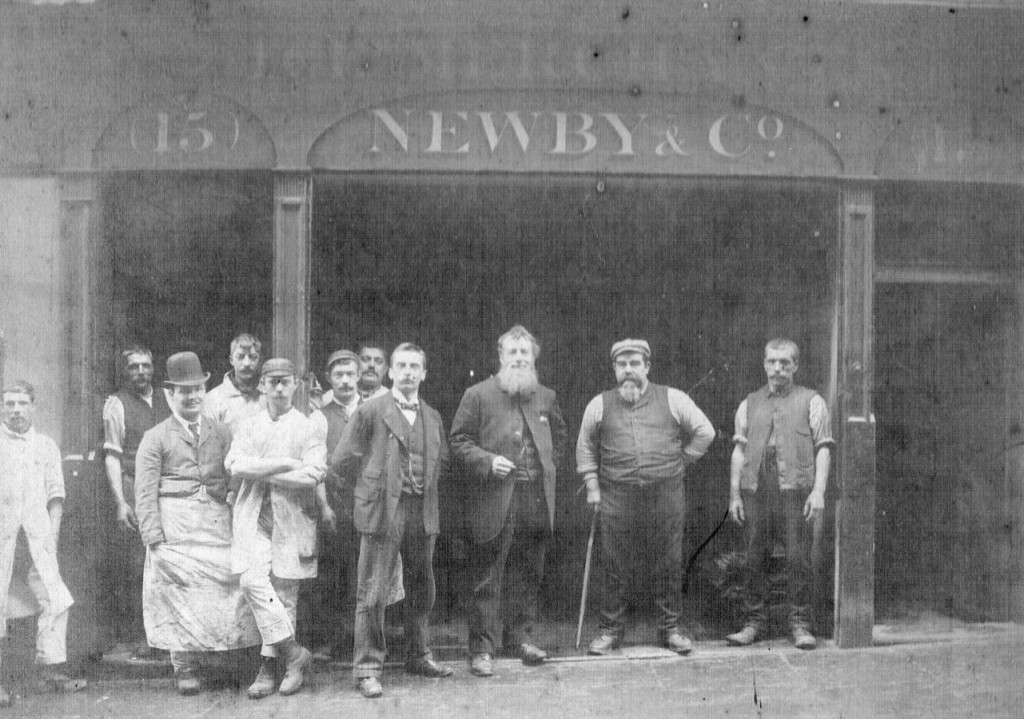 Black and white image of 11 men in the open front of the Newby and Co offices
