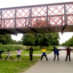 Photo of children holding hands and stretching under the bridge to nowhere to discover how wide the canal was.